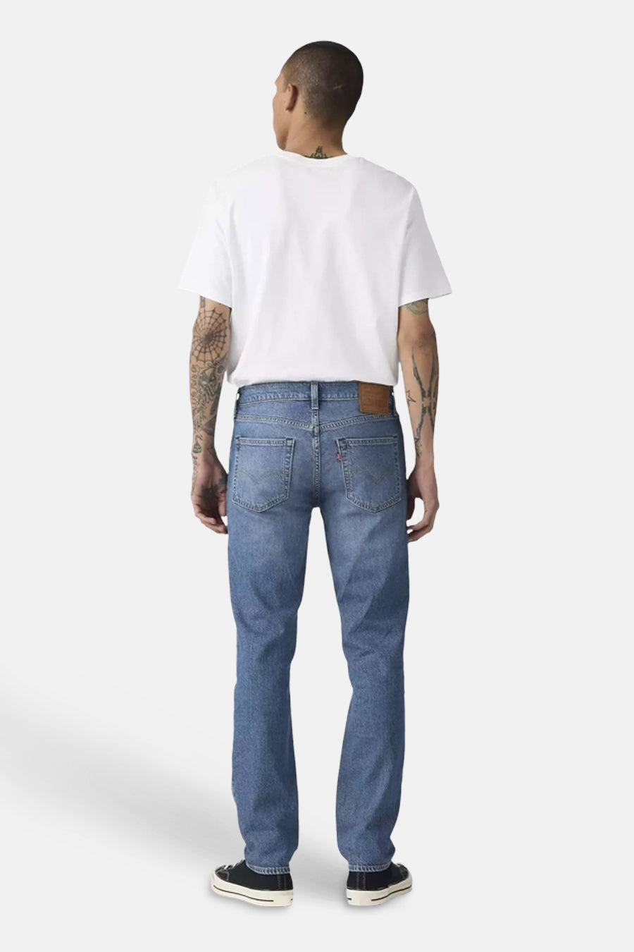 Slim jeans in middenblauw denim van Levi's® met bruine leren patch en rode tab, achterkant getoond.