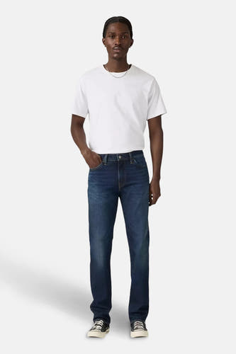 Donkerblauwe slim fit jeans van Levi's, met een witte T-shirt en zwarte sneakers.
