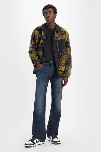 Bootcut jeans van denim van Levi's, met een vintage wassing, gecombineerd met een zwart T-shirt en een fleece jack met print.
