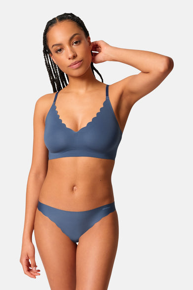 Blauwe beha van SKINY, met geschulpte rand, gedragen door een model met gevlochten haar en bijpassende slip.
