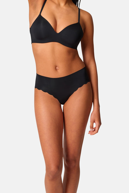 Zwarte slip van SKINY met geschulpte randen, gedragen door een model met een bijpassende zwarte bh.