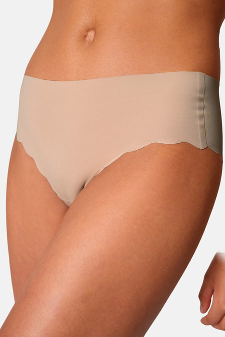 Beige naadloze slip van SKINY met golvende randen, gedragen in een cropped zij-aanzicht.