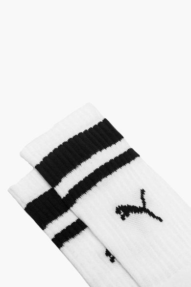 Chaussettes blanches de PUMA avec des rayures noires sur le dessus et un logo noir.