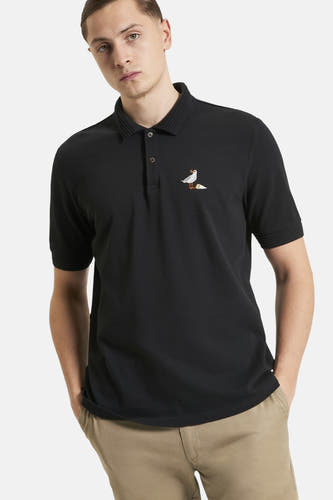 Zwarte polo met korte mouwen van BEN SHERMAN, met geborduurde zeemeeuw en effen kaki broek.

