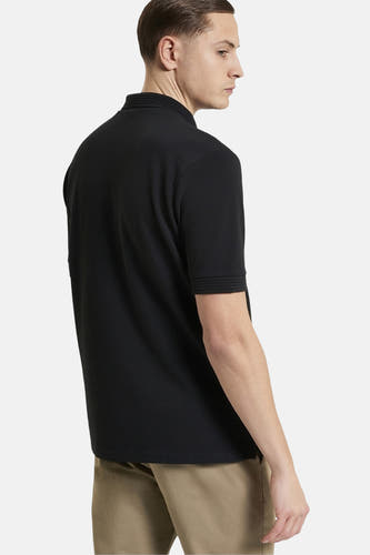 Zwart poloshirt met korte mouwen van BEN SHERMAN, gezien van de zijkant, gecombineerd met een kaki broek.