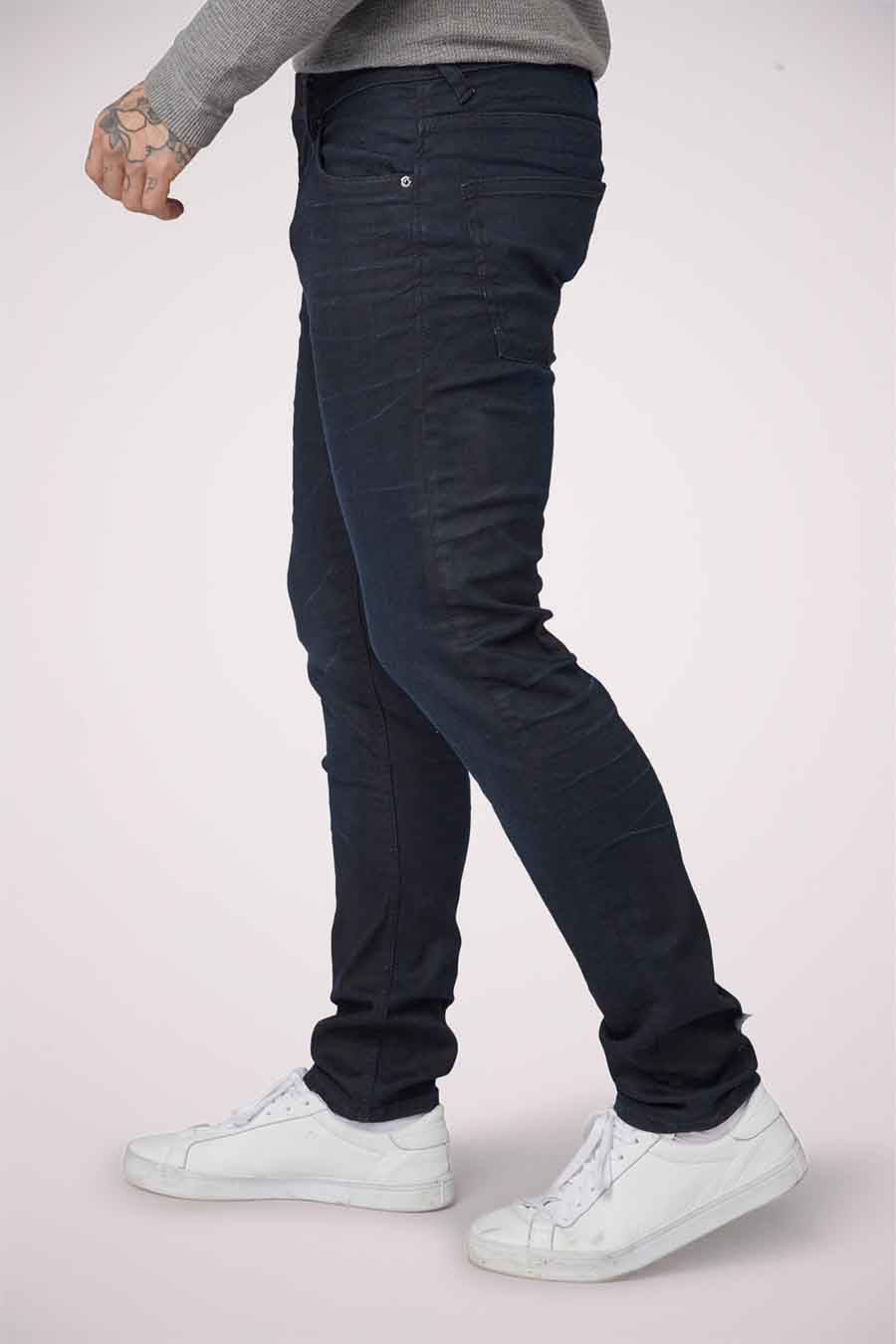 Slim fit jeans van blauwzwarte denim van TOM TAILOR, met casual witte sneakers en grijze trui, zij aanzicht.
