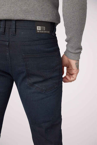 Blauwzwarte slim jeans van TOM TAILOR DENIM, met een achterzak met stiksels en een grijze trui.