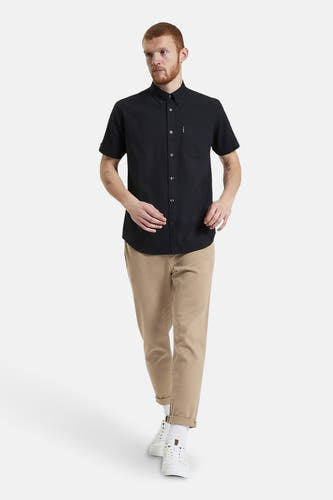 Zwart overhemd met korte mouwen van BEN SHERMAN, met borstzak, gedragen met kaki broek en witte sneakers.