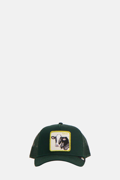 Groene pet van Goorin met een vierkante patch van een zwart-witte koe aan de voorkant.
