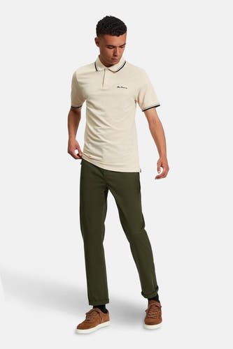 Groene chino van BEN SHERMAN, gecombineerd met een crèmekleurig poloshirt en bruine suède schoenen.
