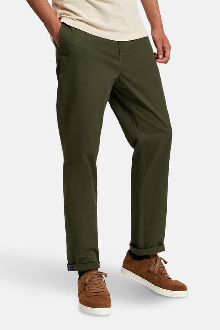 Groene chino van BEN SHERMAN, met opgerolde broekspijpen en bruine suède schoenen.