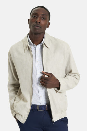 Beige, korte jas van BEN SHERMAN, met een rits aan de voorkant en een blauwe broek met riem.
