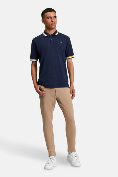 Polo bleu à manches courtes de BEN SHERMAN, avec des rayures jaunes et blanches sur le col et les manches.