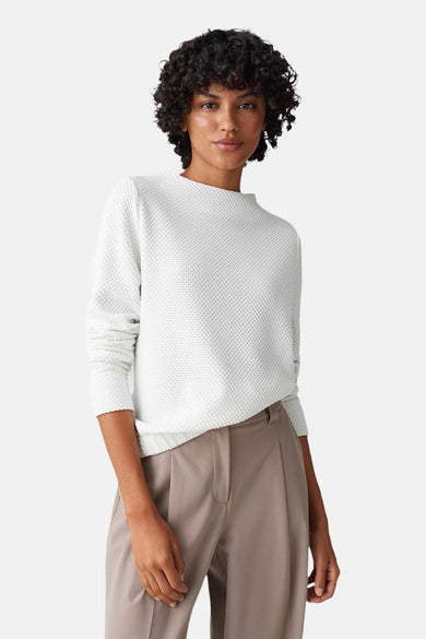 T-shirt blanc à col rond d'OPUS, avec une subtile texture à carreaux, associé à un pantalon brun large et des chaussures noires.