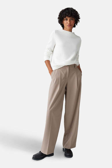 Witte trui met ronde hals van OPUS, met een subtiele wafeltextuur, gecombineerd met wijde bruine pantalon en zwarte schoenen.
