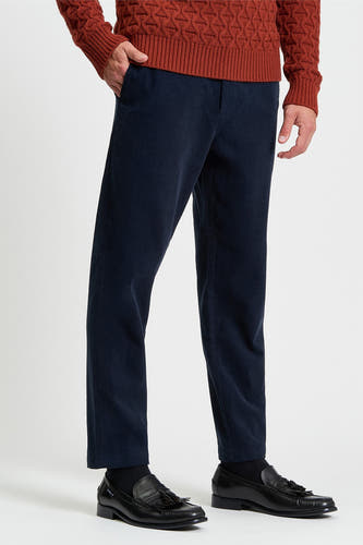 Blauwe broek van BEN SHERMAN, gemaakt van corduroy stof, gedragen met zwarte schoenen.
