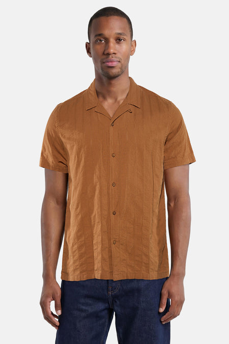Bruin overhemd met korte mouwen van BEN SHERMAN, met verticale textuur, cubaanse kraag, gedragen op een donkerblauwe spijkerbroek.