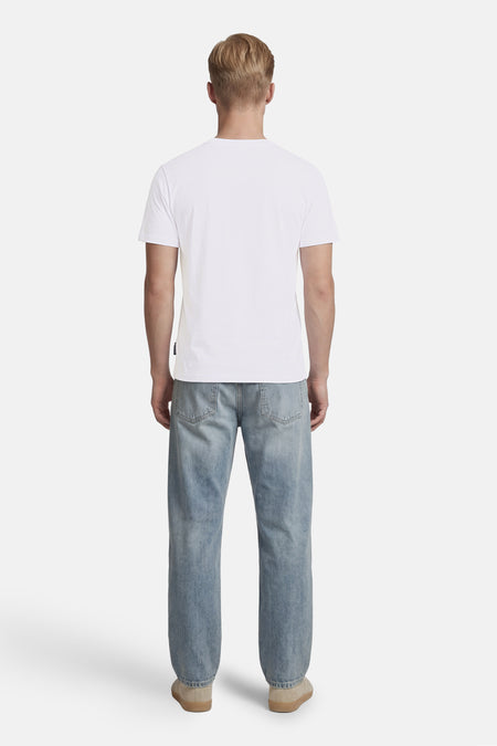 Wit T-shirt van BEN SHERMAN, rugaanzicht van een man die het draagt met een spijkerbroek en beige schoenen.