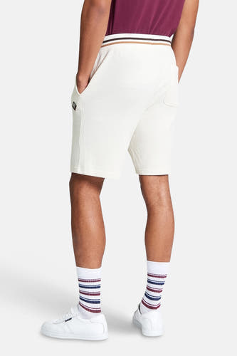 Ecru short van BEN SHERMAN, met gestreepte tailleband en gedragen met gestreepte sokken en witte sneakers.
