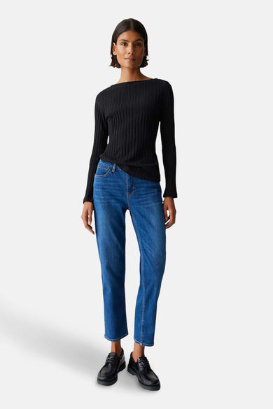 Zwarte trui met ronde hals van OPUS, met lange mouwen en een ribgebreide textuur, gecombineerd met blauwe jeans en zwarte schoenen.

