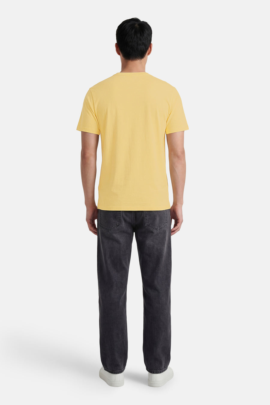 Geel T-shirt met fijne textuur van BEN SHERMAN, achteraanzicht, gecombineerd met donkergrijze jeans en witte sneakers.