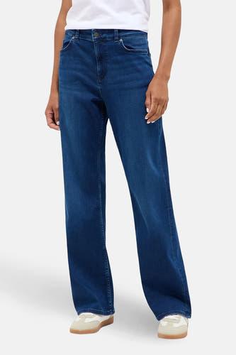 Jean large taille moyenne bleu denim de MUSTANG, porté avec un t-shirt blanc et des baskets blanches.
