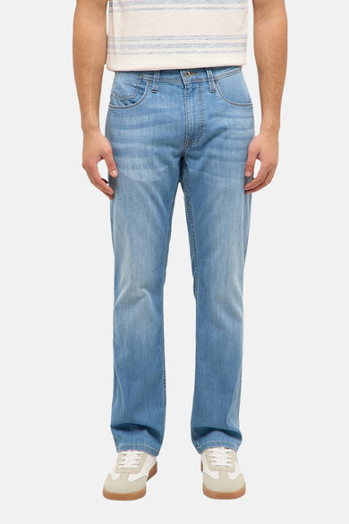 Lichtblauwe straight jeans van MUSTANG met lichte wassing, gedragen met gestreept T-shirt en witte sneakers.