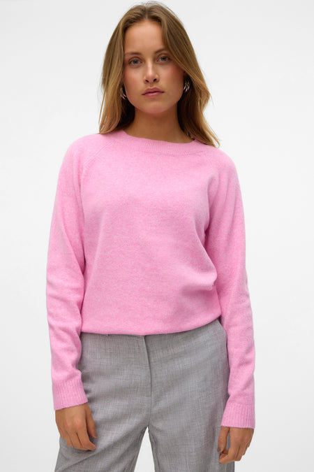 Roze trui met ronde hals van VERO MODA®, gecombineerd met een grijze pantalon en zilveren oorbellen.
