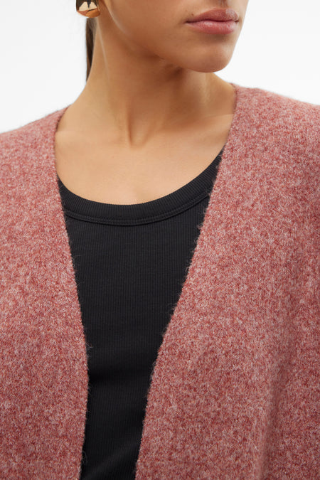 Veste brune de VERO MODA, avec une texture grossière, portée sur un t-shirt noir et des boucles d'oreilles dorées.