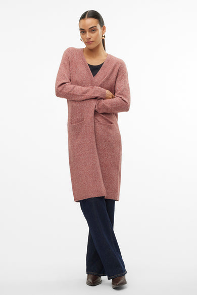 Cardigan marron de VERO MODA®, avec des manches longues, des poches et porté avec des jeans foncés et des chaussures marrons.