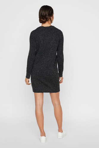 Zwarte jurk met lange mouwen van Vero Moda, gezien van achteren met eenvoudige witte sneakers.
