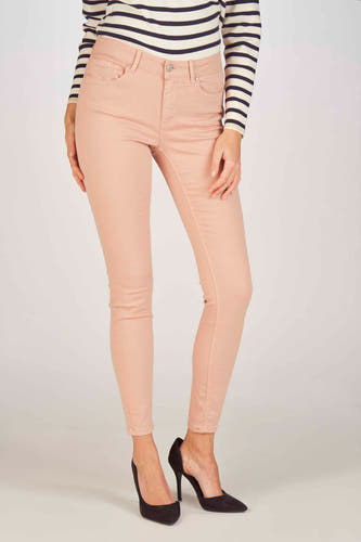 Jean skinny rose de VERO MODA, associé à une chemise rayée et des escarpins noirs.