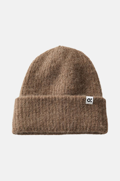 Bruine muts van OPUS, met een grof gebreide textuur en een klein merklabel aan de rand.
