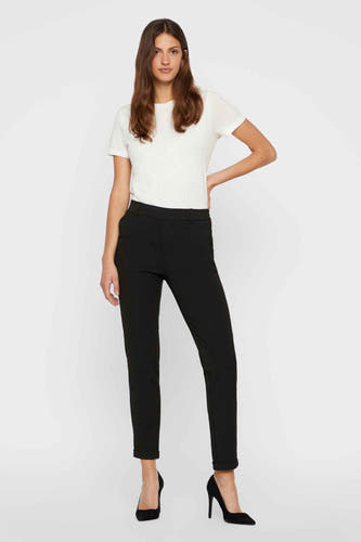 Pantalon de costume noir Vero Moda avec une taille haute et un zip serré, associé à un T-shirt blanc et des baskets noires.