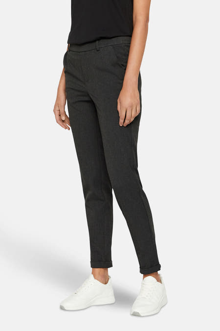 Grijze kostuumbroek van VERO MODA®, met omslagdetail en witte sneakers.
