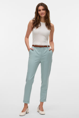 Groene kostuumbroek van VERO MODA, met een bruine riem en gecombineerd met een witte top en crèmekleurige schoenen.
