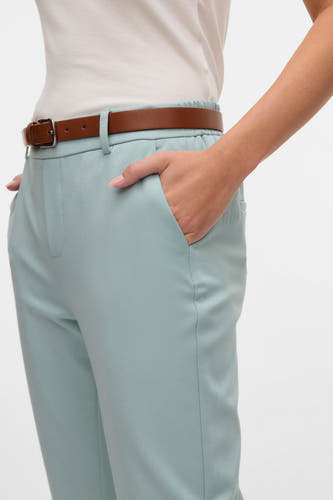 Pantalon de costume vert VERO MODA, avec une ceinture marron et une main dans la poche.