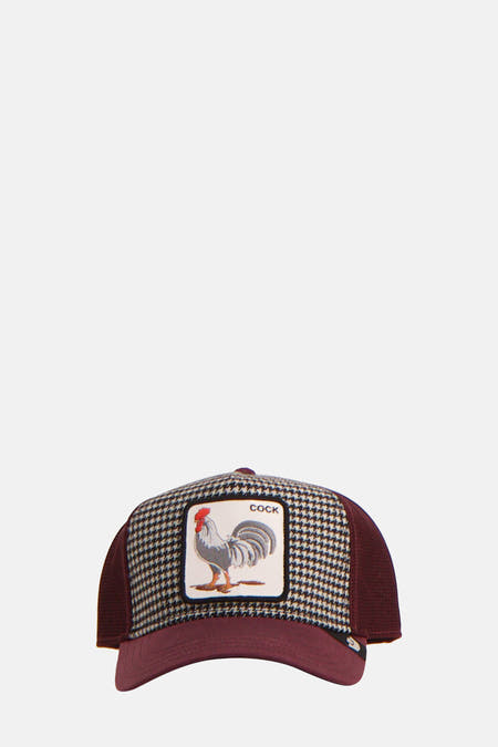 Bordeaux pet van Goorin, met een zwart-wit houndstooth motief en een patch met een haan erop.
