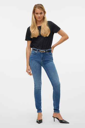 Skinny jeans in mid blue denim van VERO MODA, met een zwarte riem en zwarte schoenen.