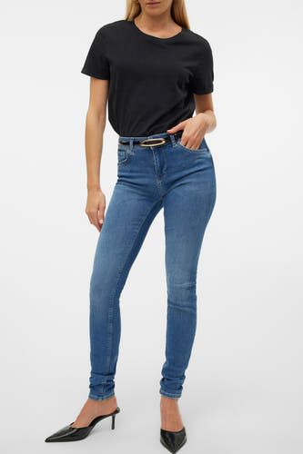 Jean skinny bleu de VERO MODA®, avec une ceinture noire et un haut noir.