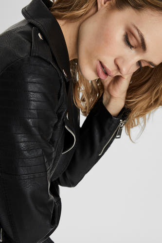 Manteau de cuir noir Vero Moda avec des détails à glissière et une douce texture, porté par un modèle.