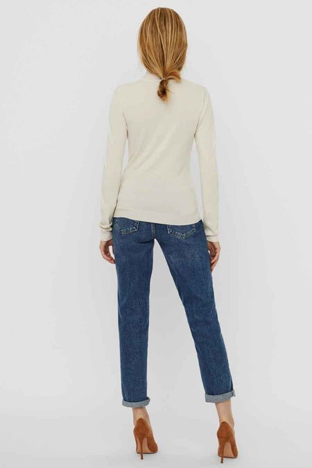 Beige trui van VERO MODA, achterkant gezien, gecombineerd met jeans en bruine hakken.