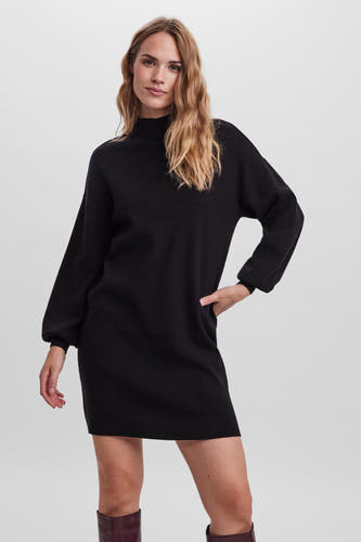 Robe noire à manches longues de VERO MODA, présentée avec un col montant et des bottes en cuir.