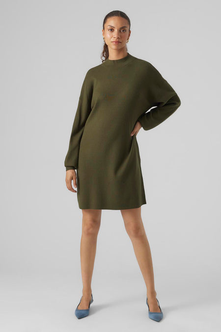 Groene jurk met lange mouwen van VERO MODA, met een hoge halslijn en blauwe schoenen.