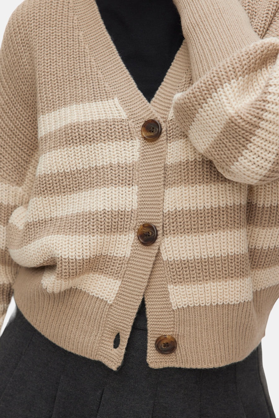 Beige gestreept gebreid vest met bruine knopen.
