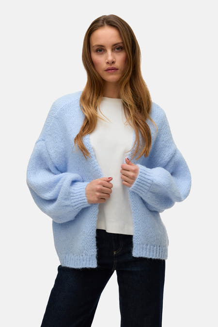 Blauw vest van VERO MODA, gedragen over een wit T-shirt en donkere jeans.