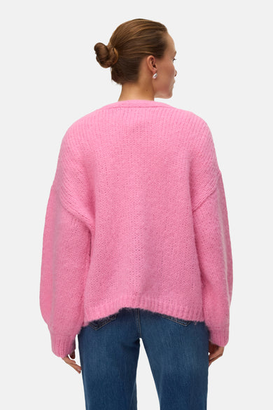 Roze cardigan van Vero Moda, met een zachte gebreide textuur, gecombineerd met een blauwe jeans.
