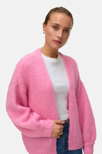 Cardigan rose de VERO MODA, porté sur un T-shirt blanc et un jean bleu.