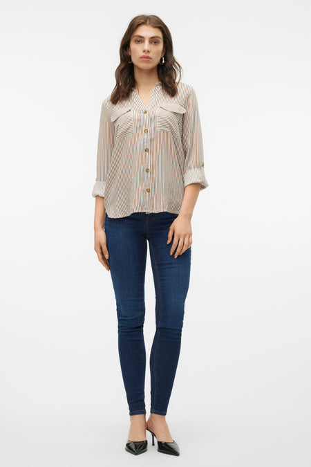 Bruin, gestreept overhemd met lange mouwen van Vero Moda, met borstzakken en opgerolde mouwen, gedragen met een donkere jeans en zwarte hakken.
