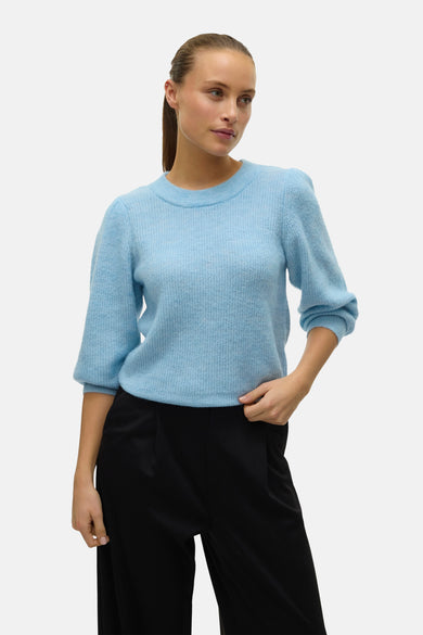 Blauwe trui met ronde hals van VERO MODA, met driekwart pofmouwen en gecombineerd met een zwarte broek.
